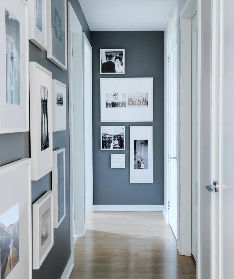 gallery wall in small hallway with wood flooring