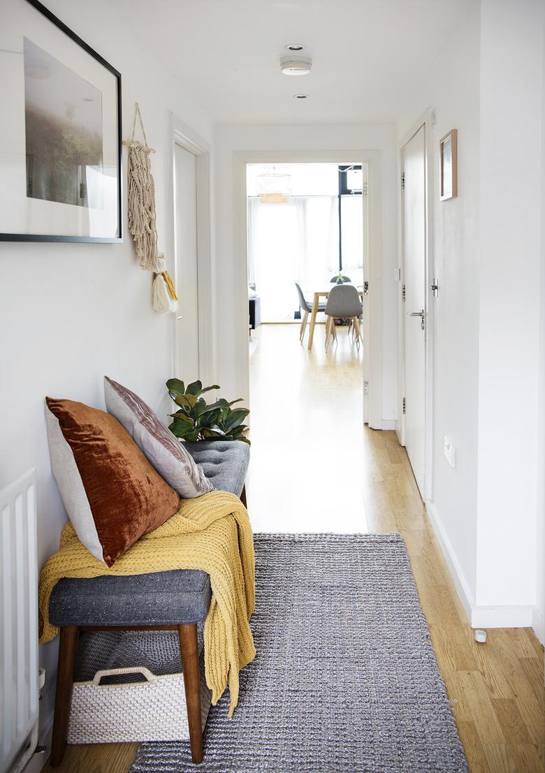 small hallway with bench and baskets for shoes