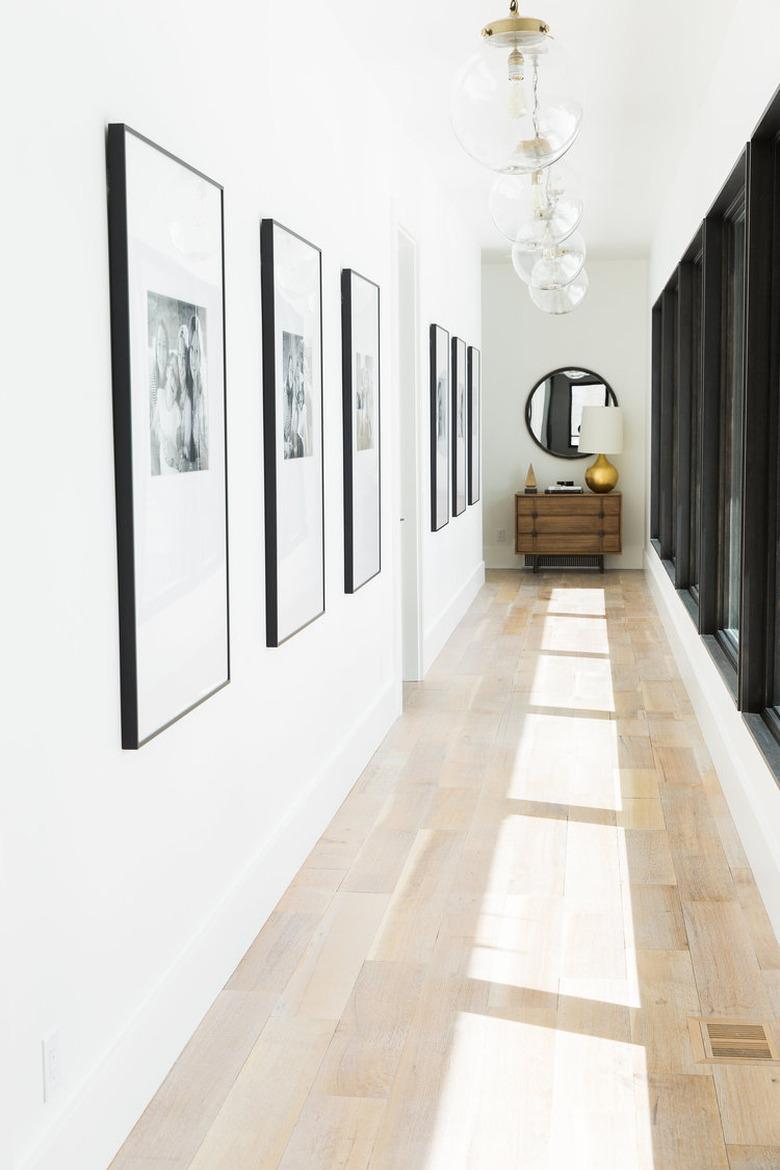 long narrow hallway with pendant lighting and console table