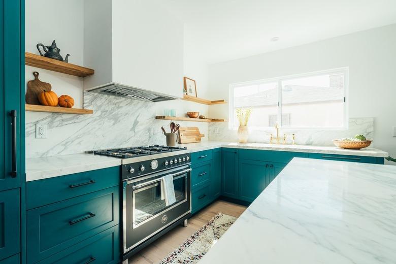 teal l-shaped kitchen with marble backsplash