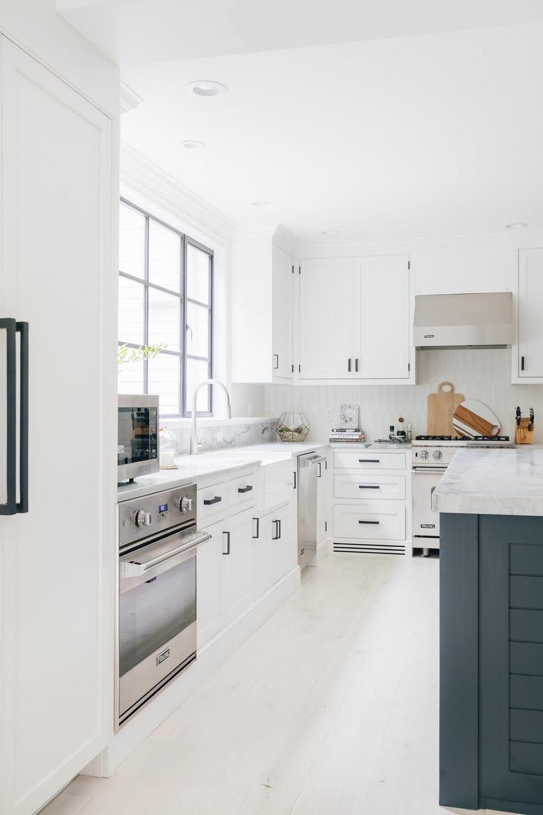 white l-shaped kitchen with stainless steel appliances