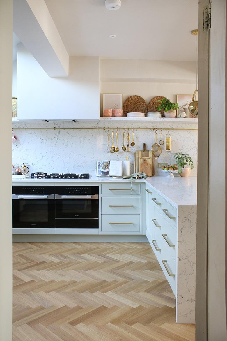 white l-shaped kitchen with open shelf and rod for cooking tools