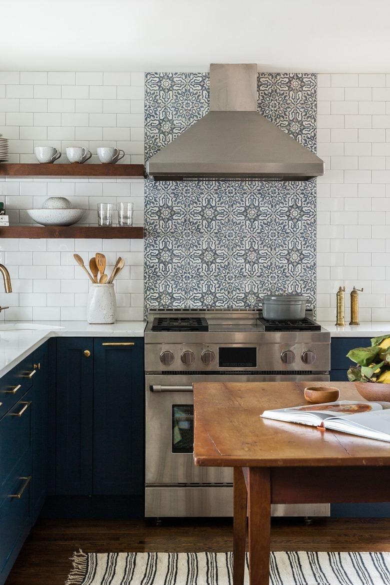 L-shaped kitchen with patterned stove backsplash and navy cabinets