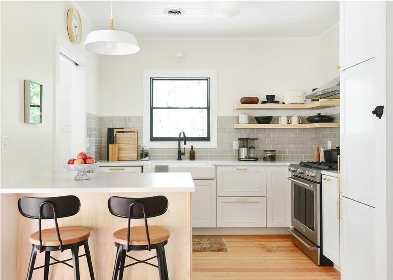 small l-shaped kitchen with white cabinets and bar