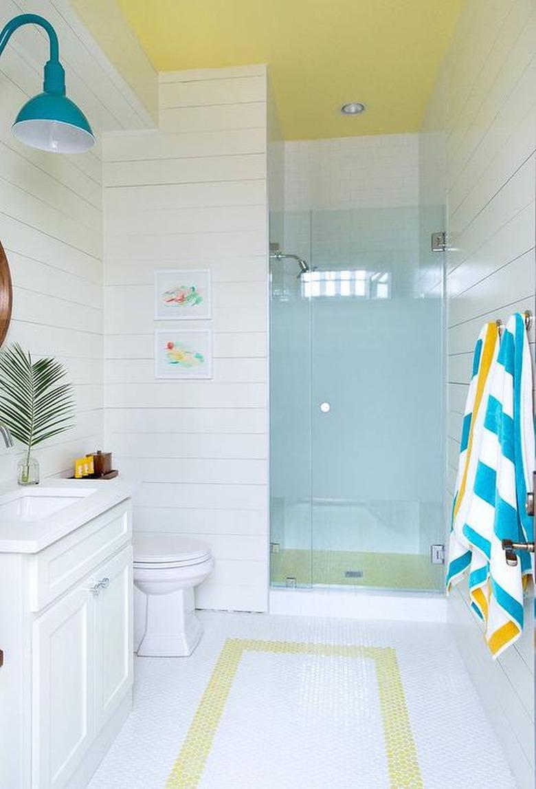 Photo of bathroom with blue glass walk-in shower.