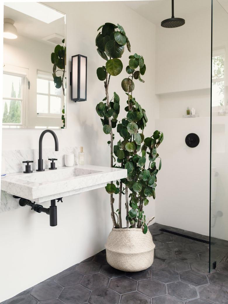 hexagon stone tile bathroom floors with white walls and black hardware