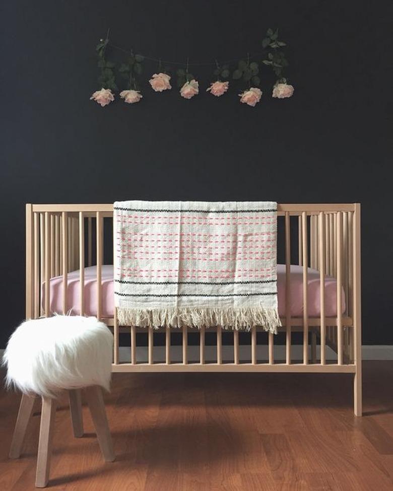 wood crib with pink bedding