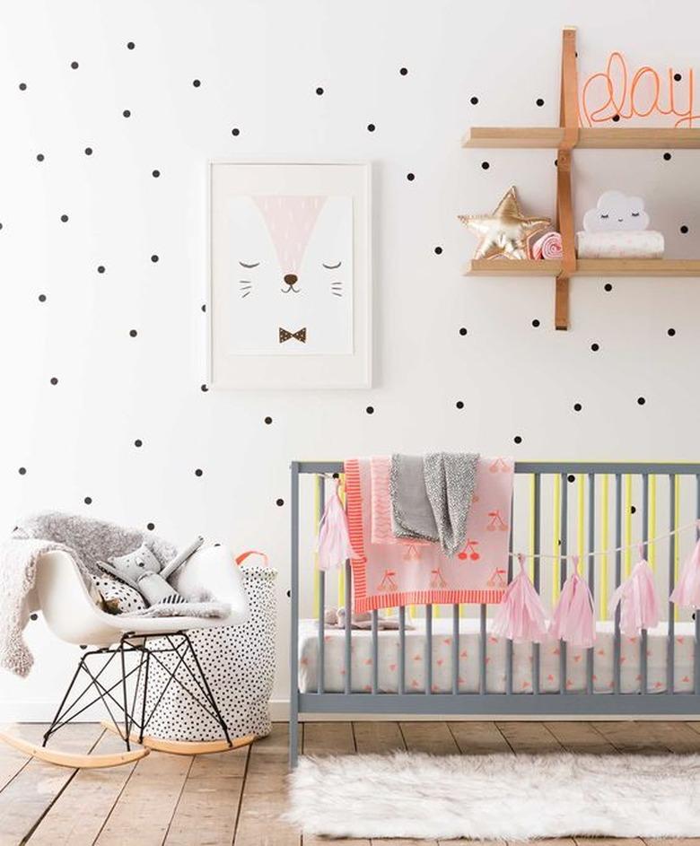 nursery with polka dot walls and grey crib