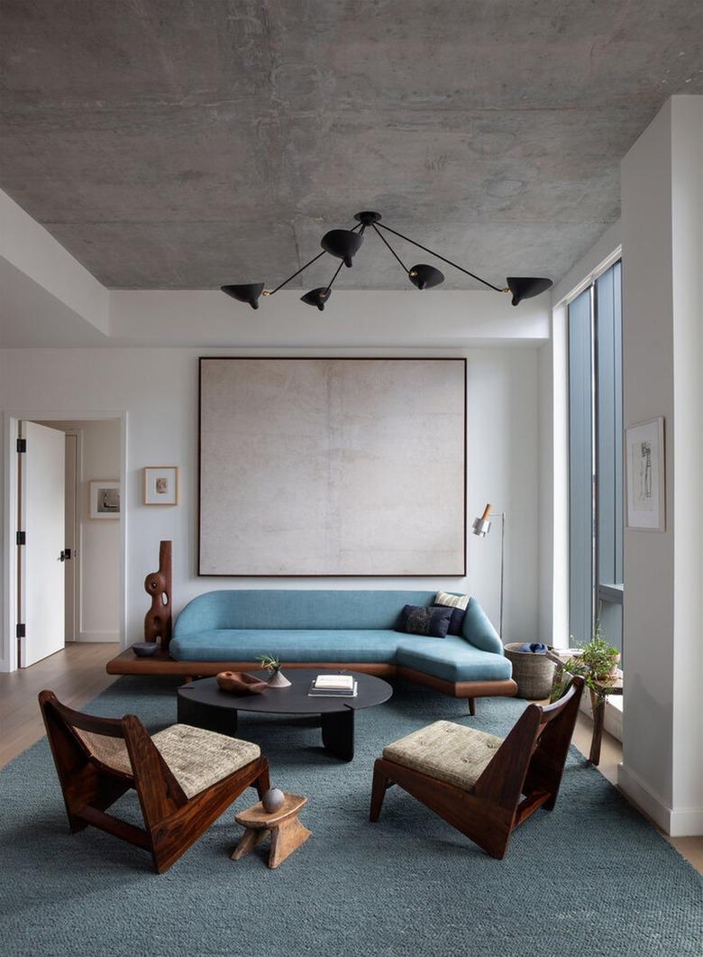 minimalist living room with white walls and concrete ceiling