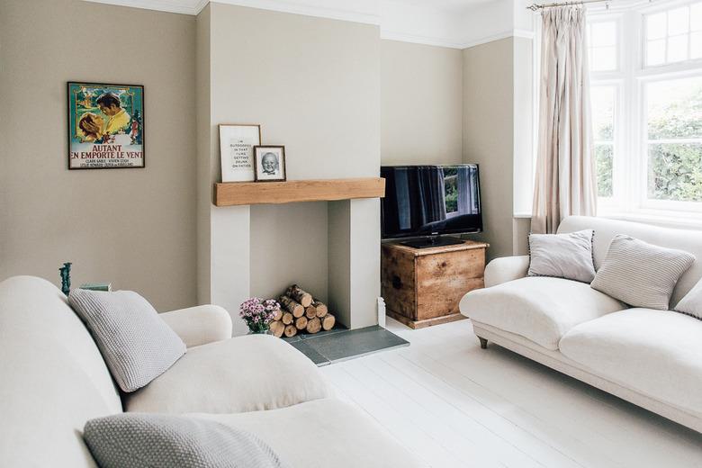 Beige walls and an unused fireplace with live-edge wood mantel.