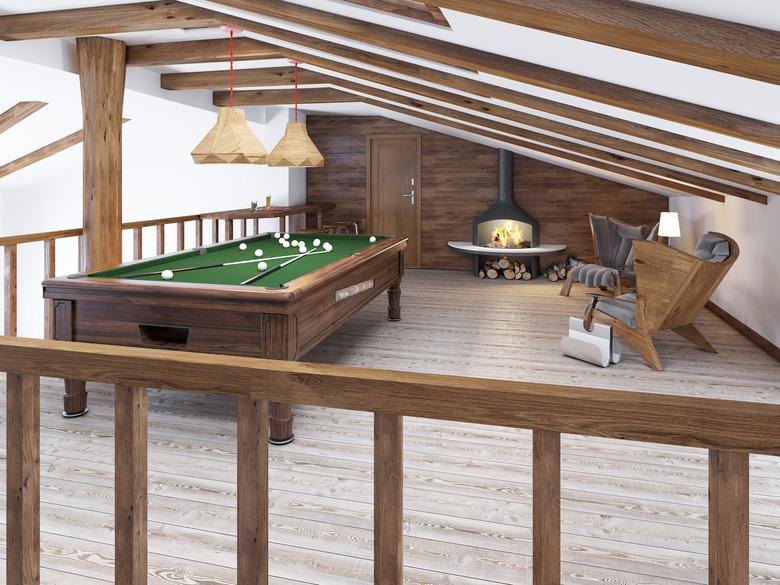 Billiard room in the attic with sitting area and fireplace.