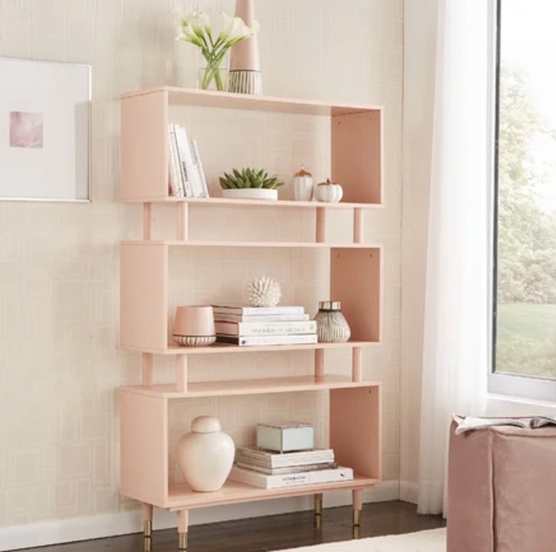 image of pink bookshelf accessorized with books, vases and plants