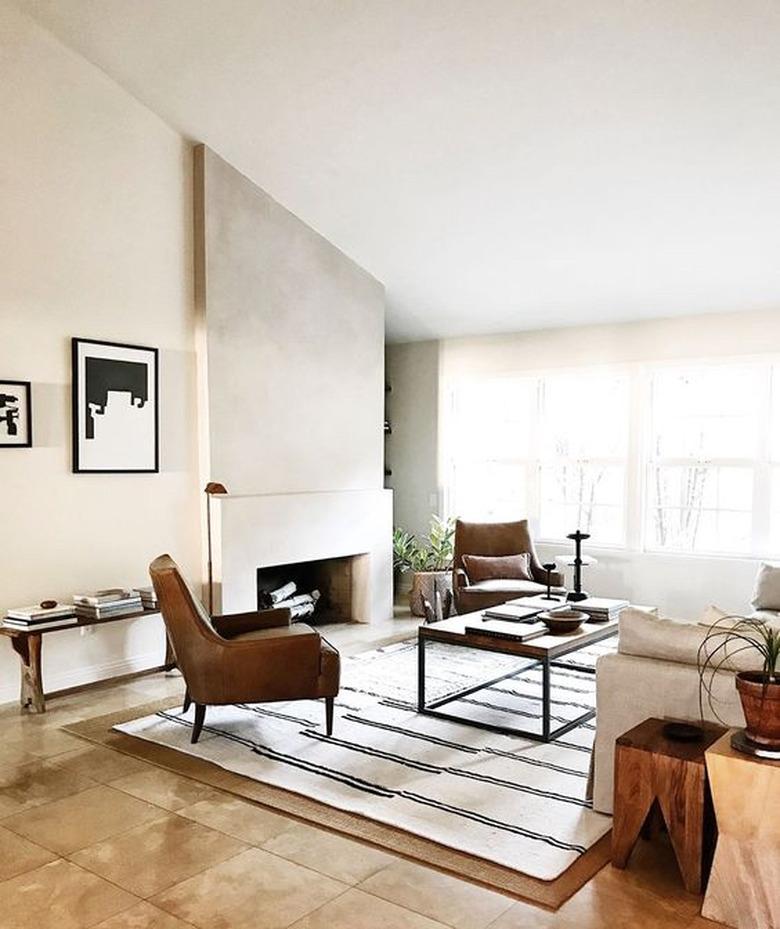 modern living room with concrete fireplace and angled ceiling