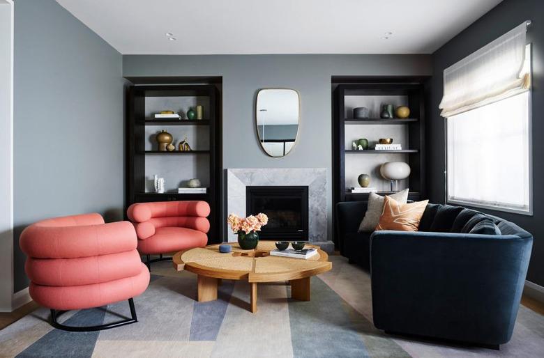 marble surround fireplace in blue-gray living room with curved furniture