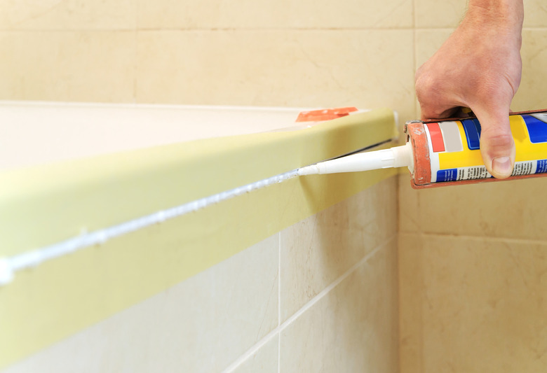 Worker applies silicone sealant.