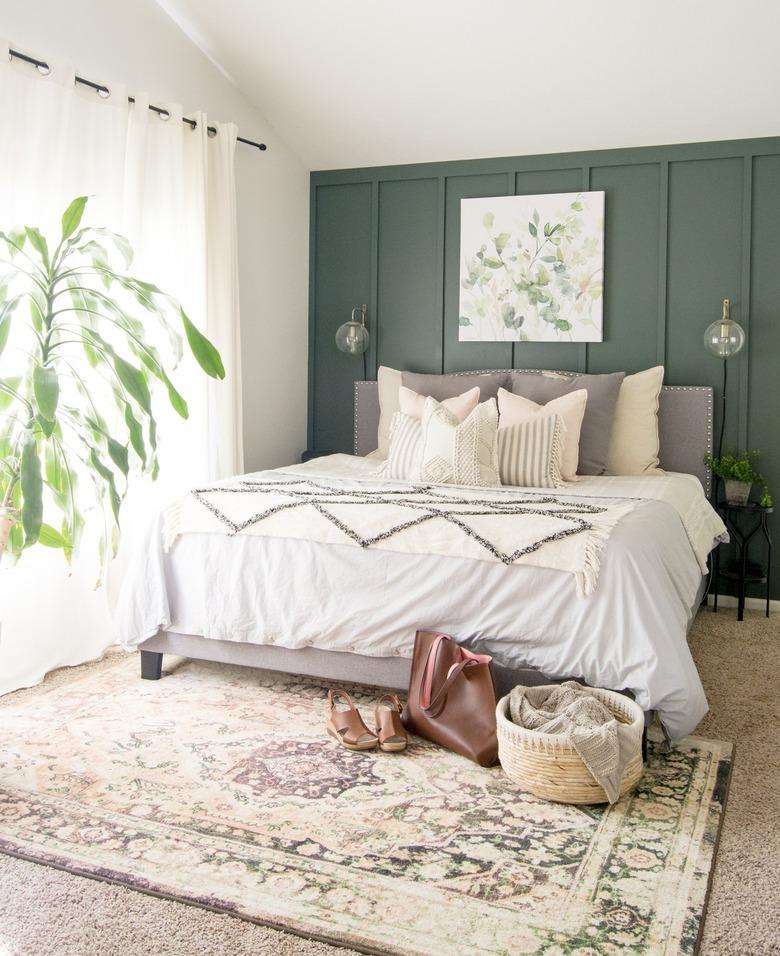 Minimalist bedroom with forest green accent wall and farmhouse bedding.