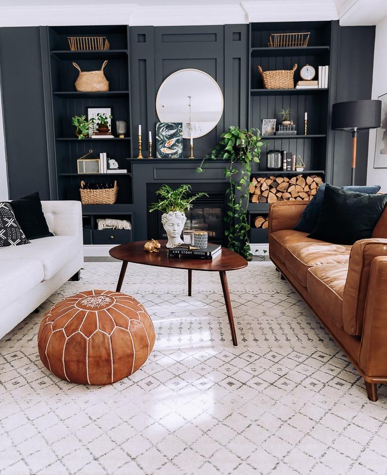 Sophisticated living room with dark gray built in bookcases and camel leather couch.