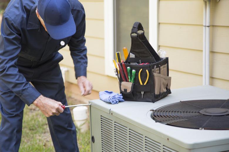 Technician services outside AC unit.