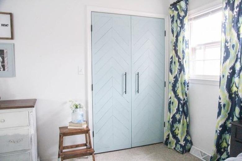 Bedroom with blue french doors and patterned curtains