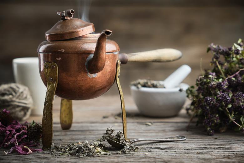 Old antique boiling teapot, mortar, dry coneflowers and thyme bunch.