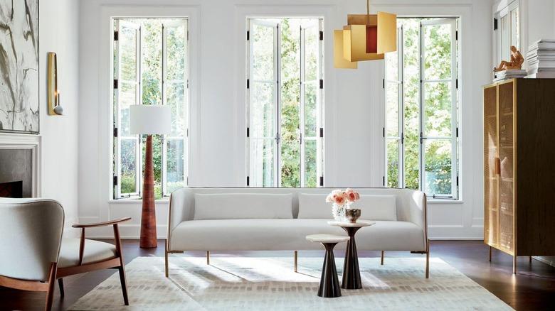 art deco apartment with white living room with brass pendant and white sofa