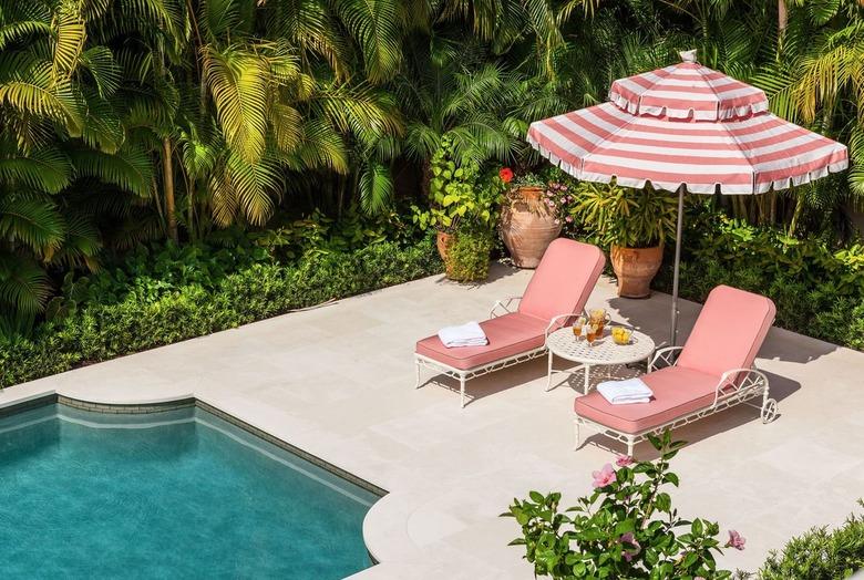 art deco decorating on a budget with lounge chairs and striped umbrella by pool