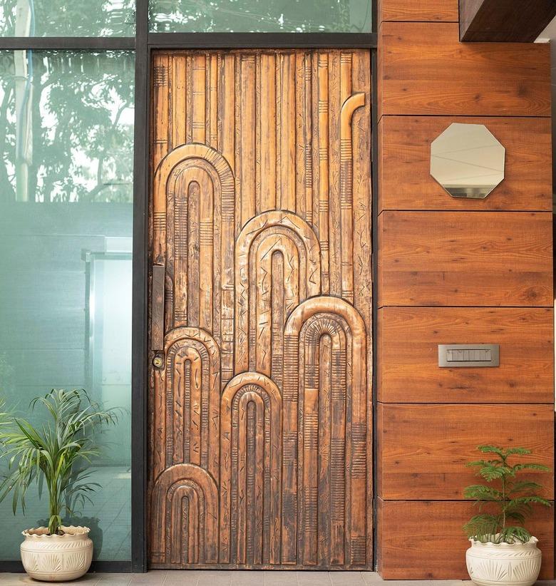 Art deco door with curved patterns in a bronze material