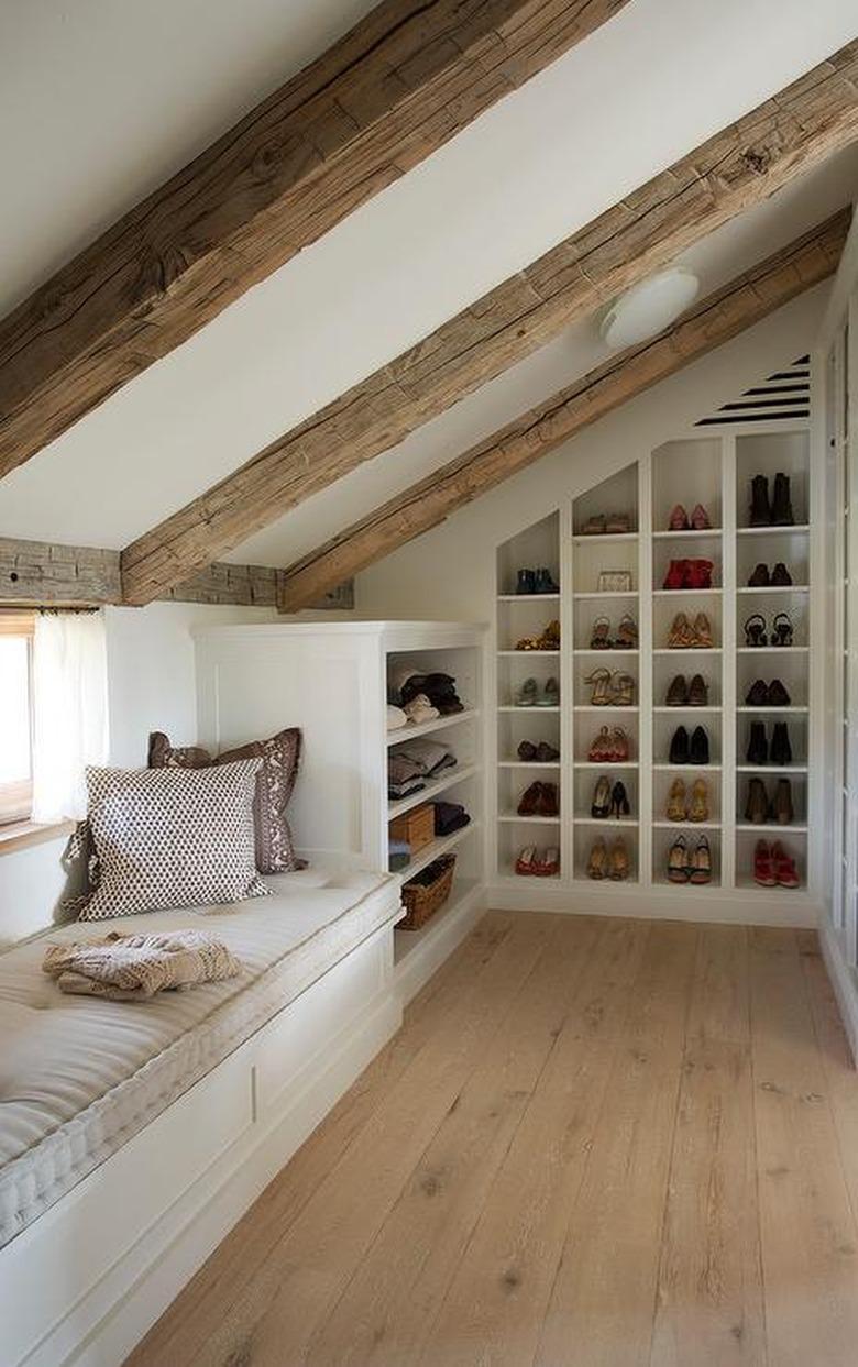 built-in attic storage in attic with exposed beams and window seat