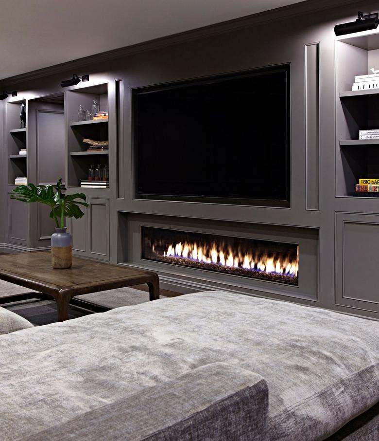 Basement with a TV and fireplace