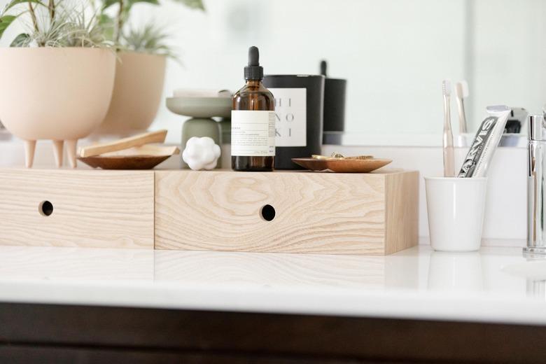 bathroom decor idea with wooden boxes on countertop for essentials