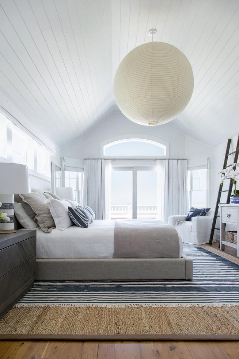 large round bedroom chandelier hanging from A-frame ceiling