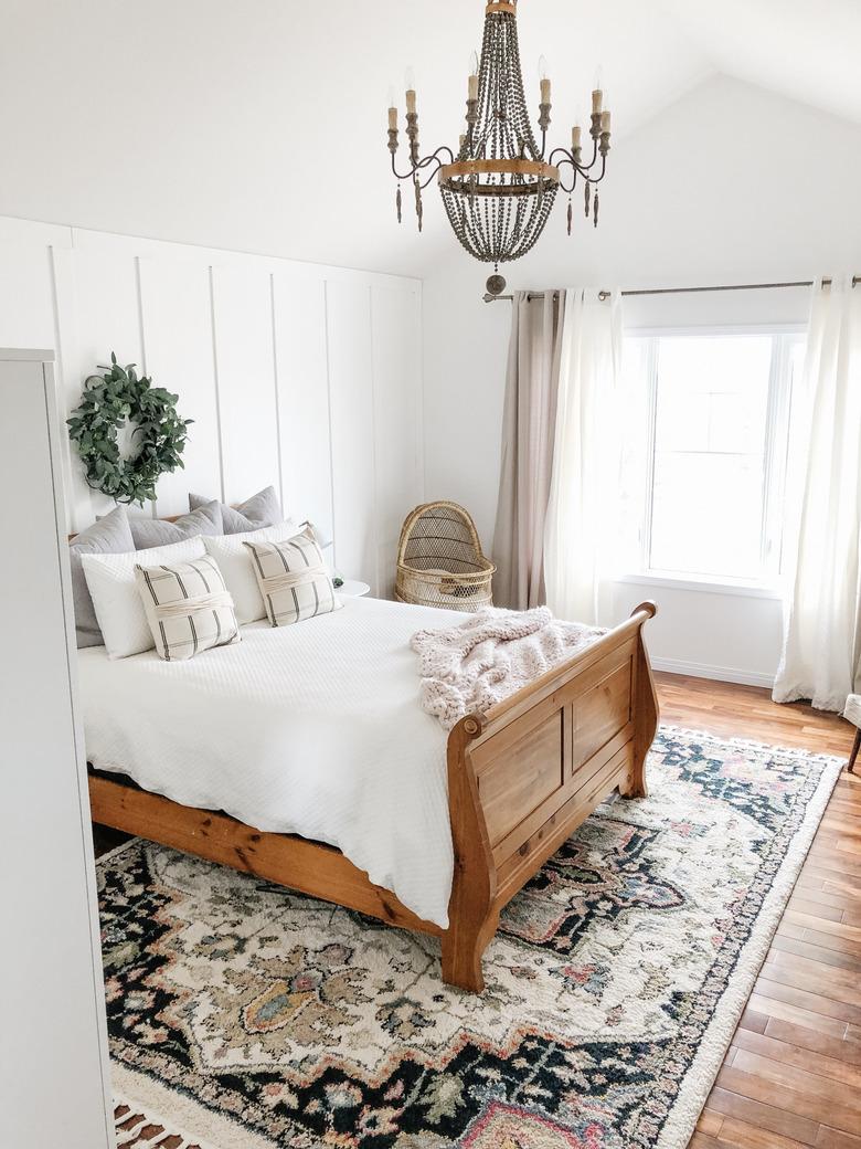 candelabra style bedroom chandelier hanging above wood frame bed