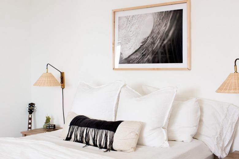 white bedroom idea with wall sconces on either side of bed and black and white photo hanging above