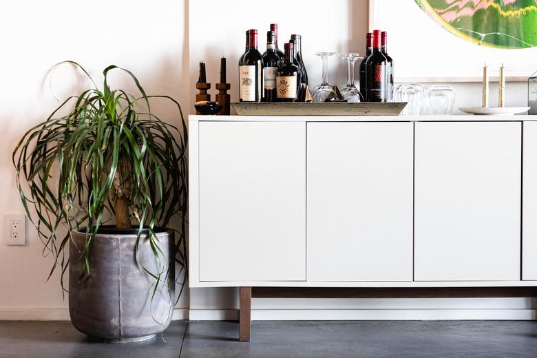 Ponytail Plant near credenza with bar items