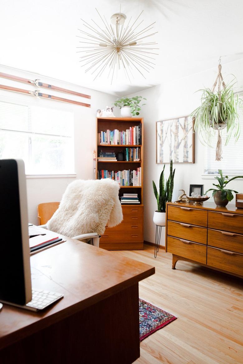 Home office with vintage wood furniture pieces and starburst chandelier