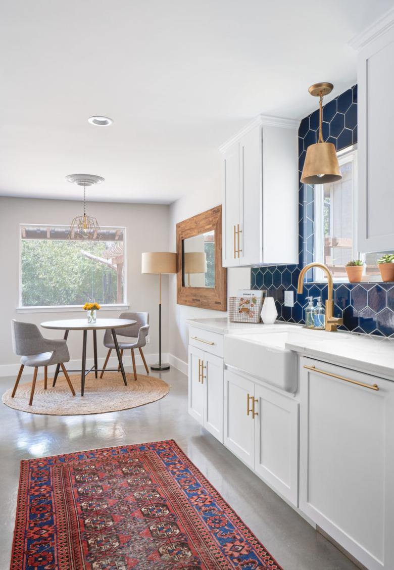 blue and gray kitchen with navy backsplash and gray flooring