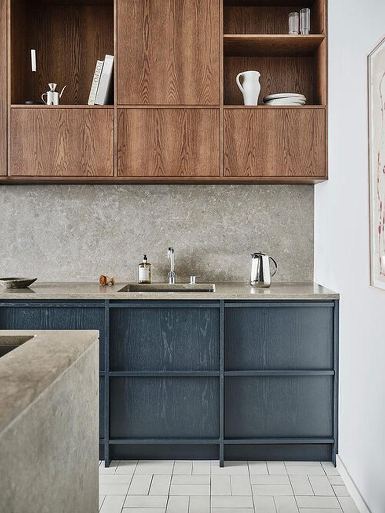 blue and gray kitchen with blue cabinets and gray countertops and backsplash