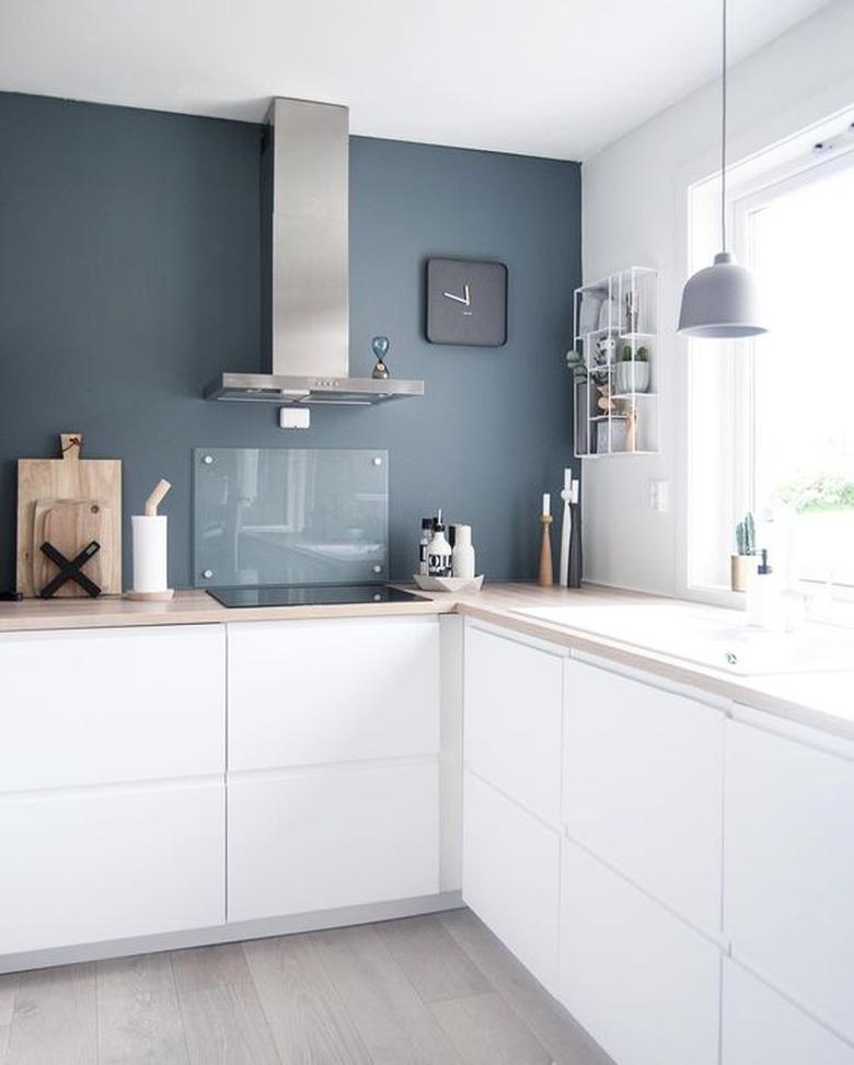 blue and white kitchen with blue feature wall