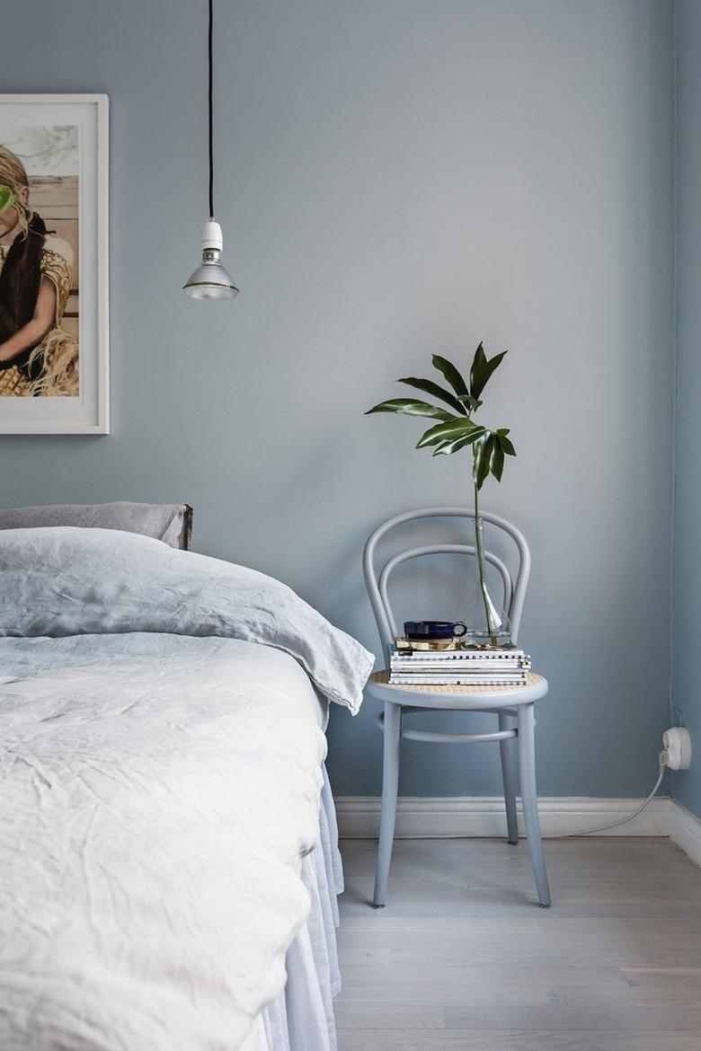 monochrome blue bohemian bedroom idea with artwork hanging above bed