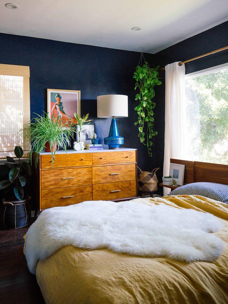 blue bohemian bedroom idea with wood dresser and yellow bedspread