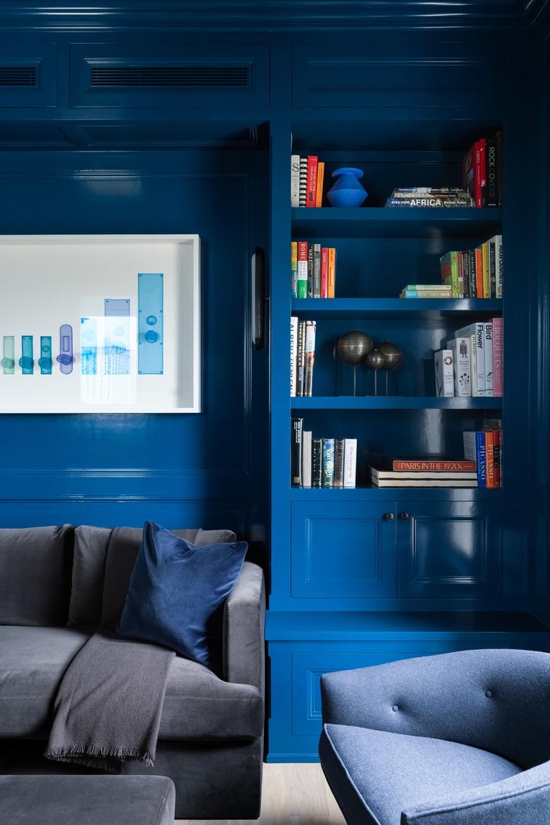 room with blue paint color on walls and bookcase