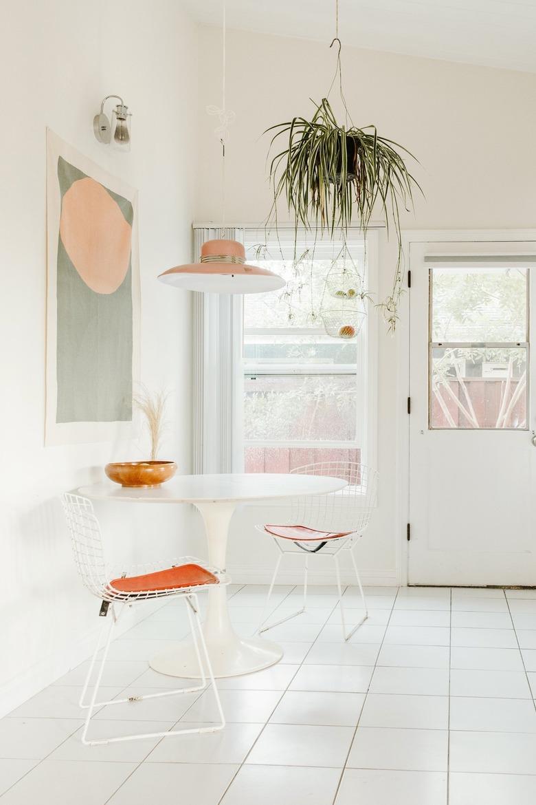 White boho kitchen with tulip table and hanging plants