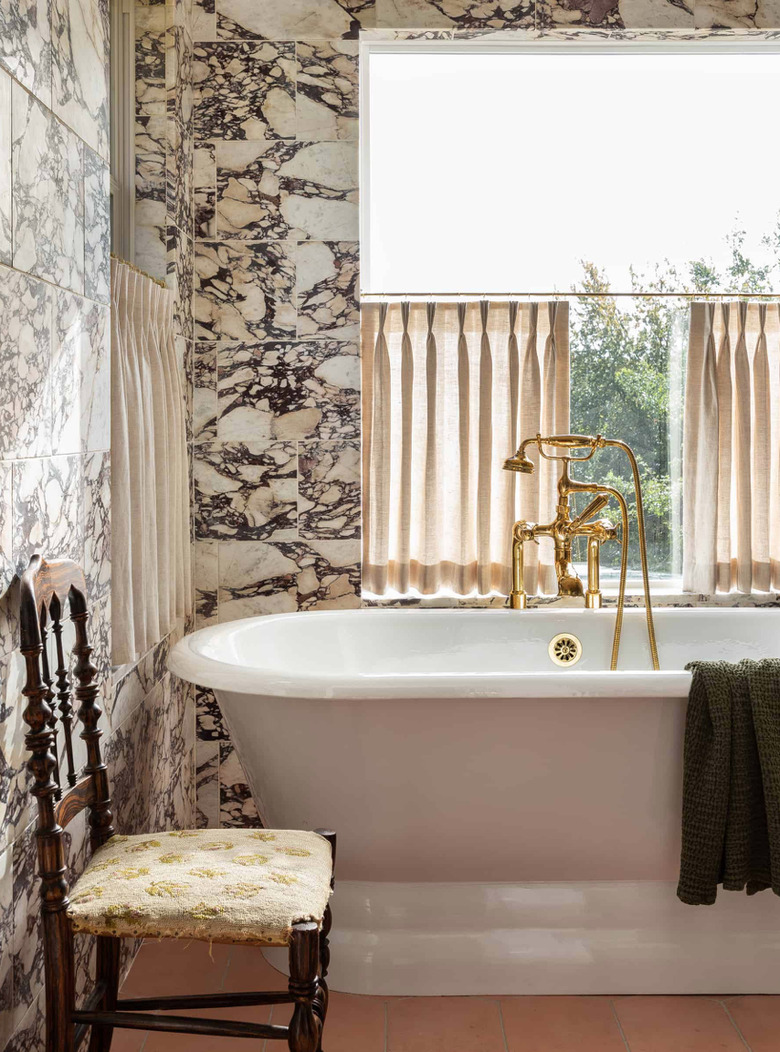 sophisticated bathroom with cafe curtains and brass bath fixtures