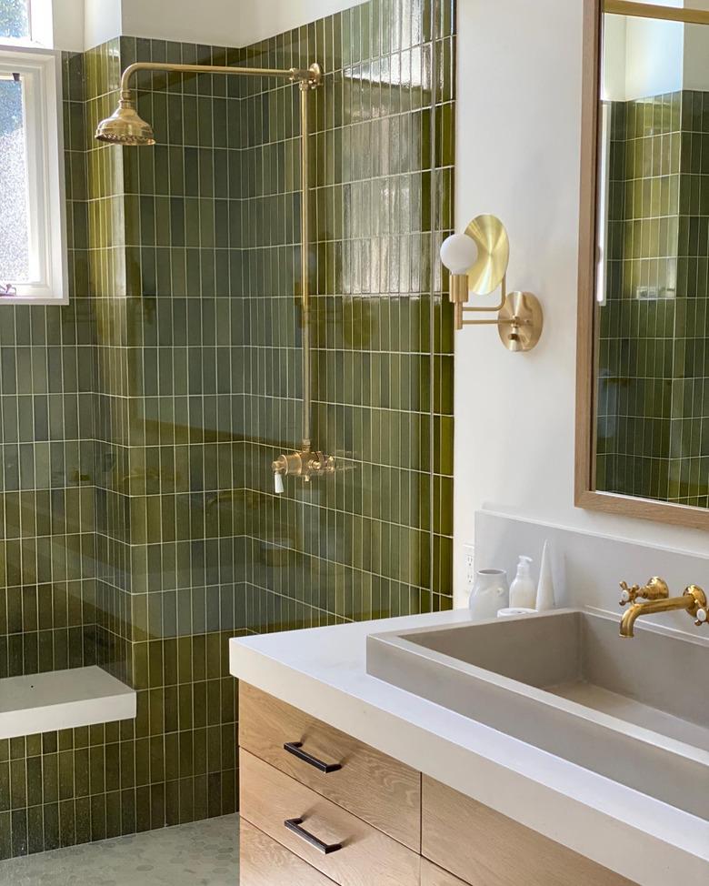 brass shower fixtures with vertically stacked green tile