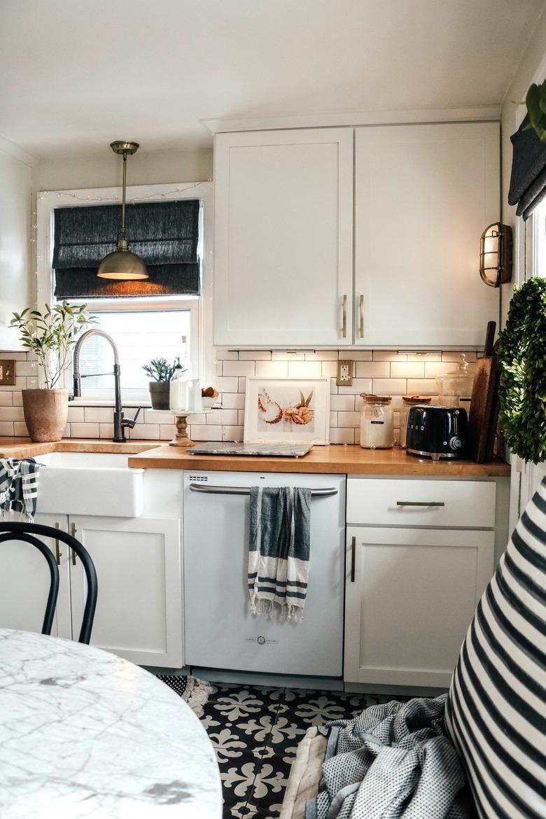 Alternative kitchen lighting idea under cabinets with wood countertops and patterned tile floor