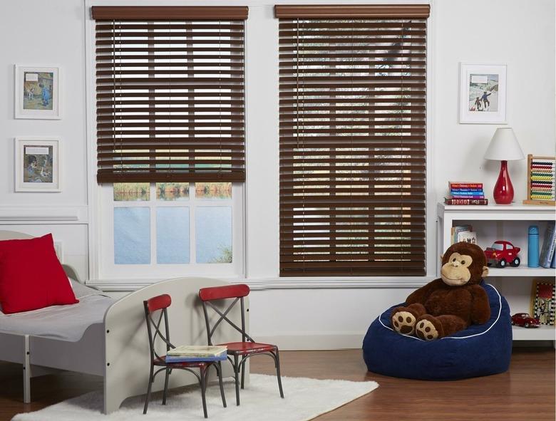 Horizontal faux wood blinds on windows in child's bedroom.