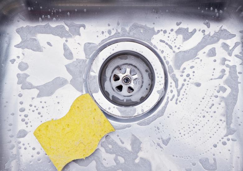 Close up sink drain and yellow sponge