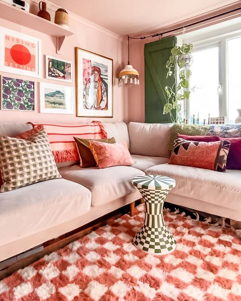 pink living room with checkerboard rug and accent table