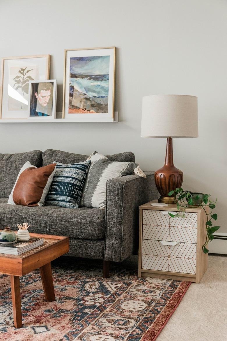 Scandinavian white and neutral nightstand with striped pattern with plant on Persian rug