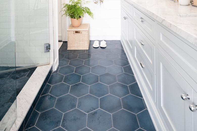 Bathroom floor with blue tile and plant on a basket